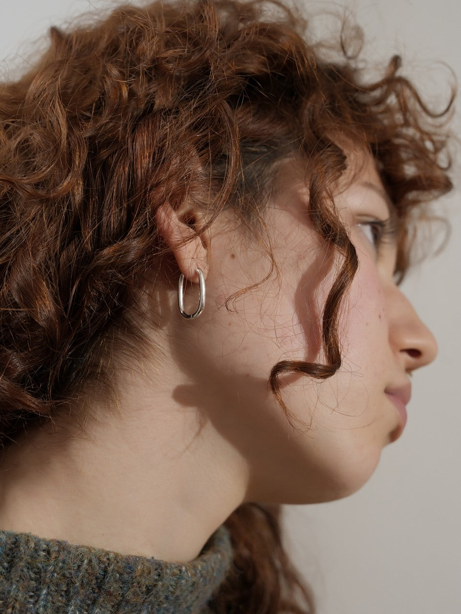 Strieborné náušnice oválne vyrobené v Taliansku detail na modelke z dola